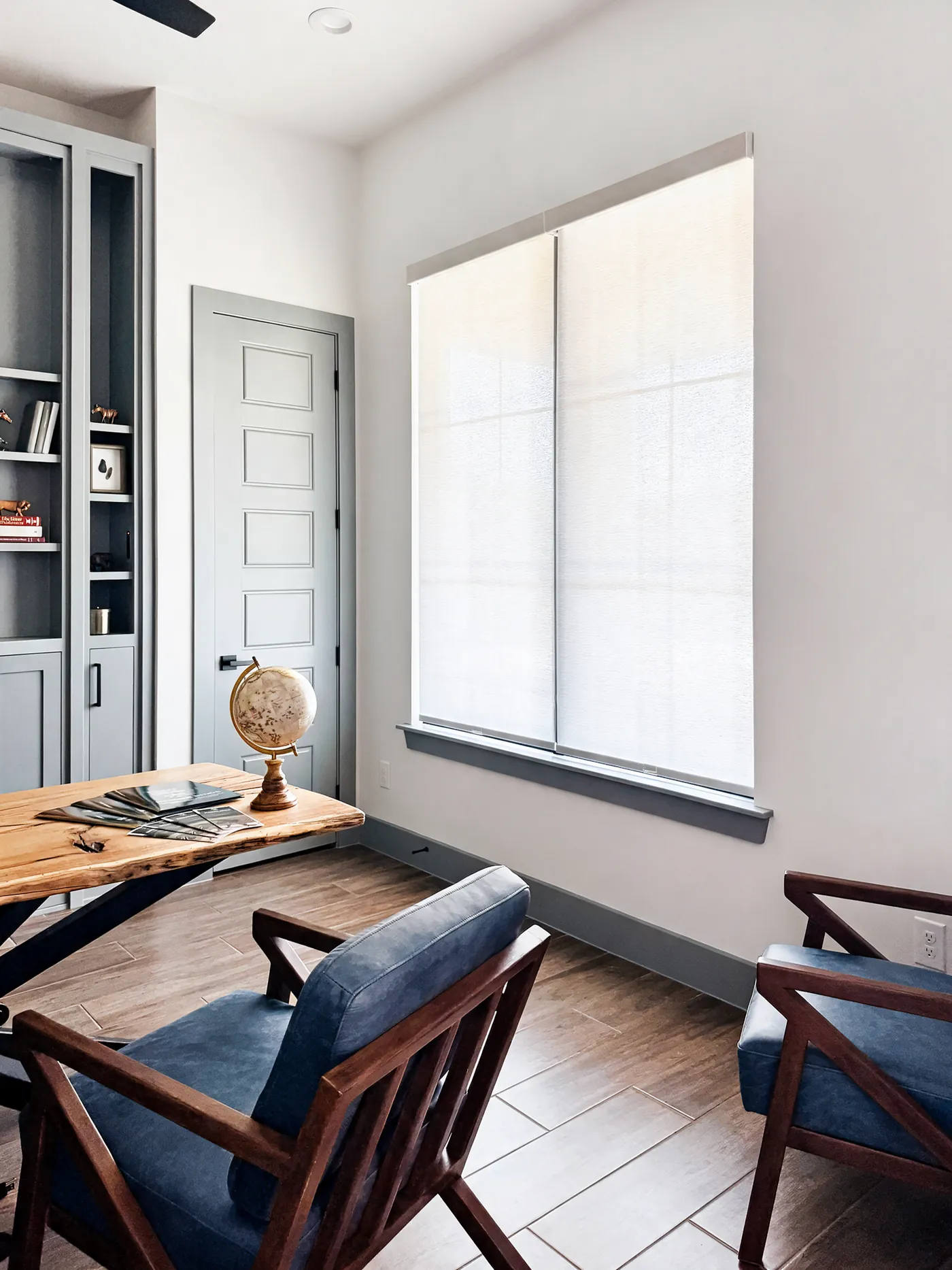 Light-filtering roller shades on a large home office window